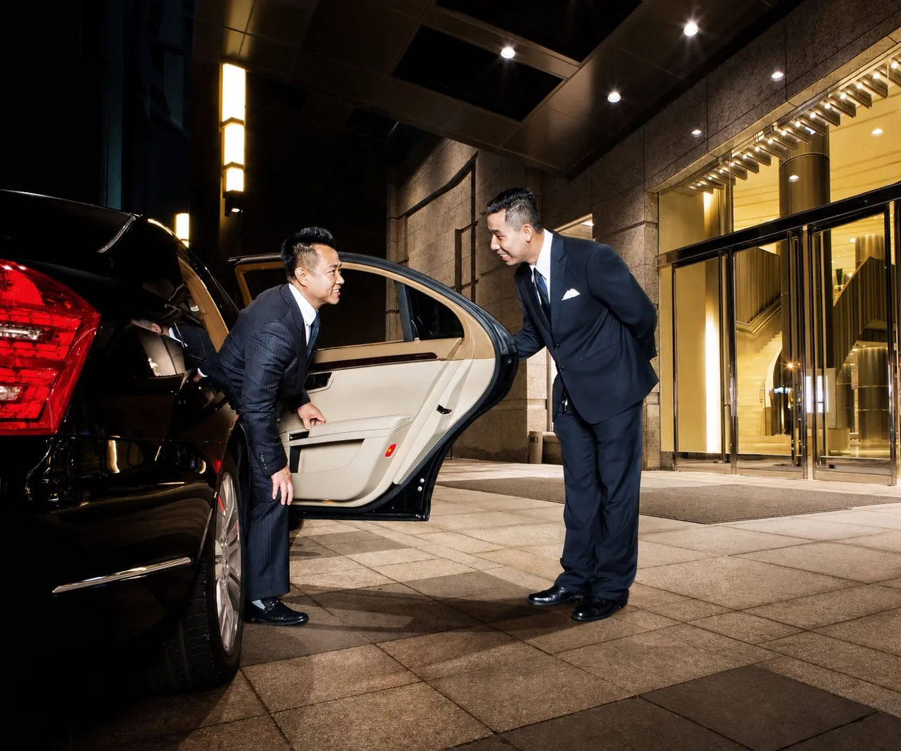 Balilimo Founder and CEO greeting a chauffeur beside a private limousine
